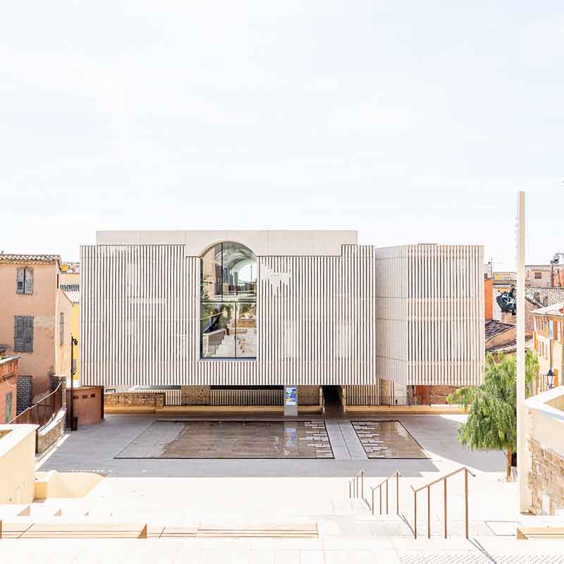 Photographie d'architecture moderne de la médiathèque Charles-Nègre à Grasse, avec sa façade en colonnes blanches et son parvis.