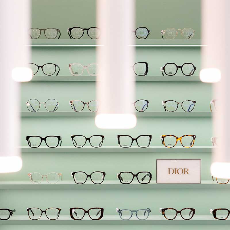 Photographe magasin Marseille : intérieur moderne d'un opticien avec présentoirs muraux en bois et comptoirs épurés.