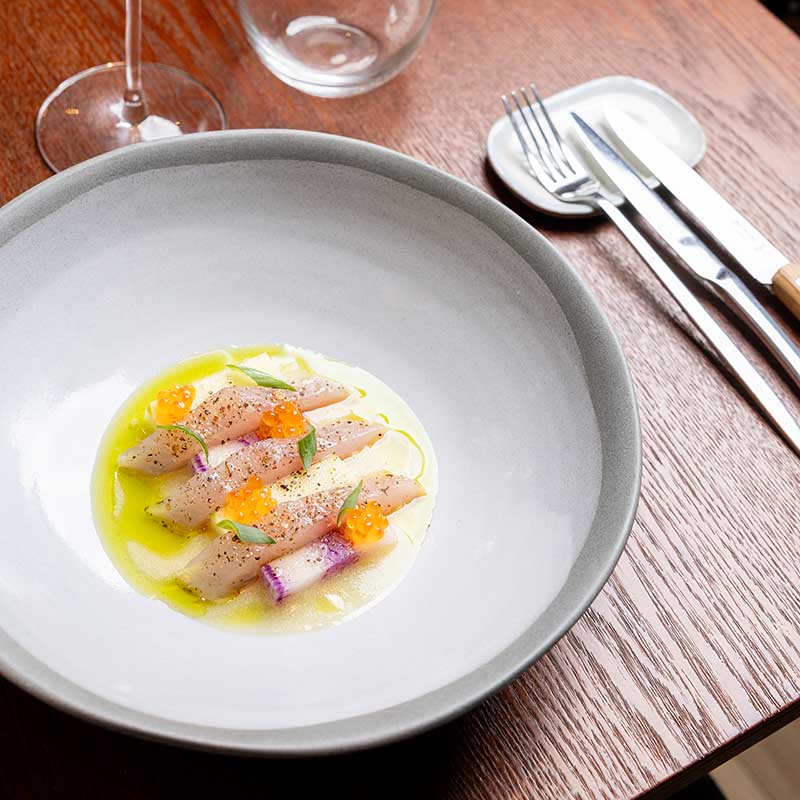 Photographe culinaire Marseille : salle de restaurant de luxe, tables nappées et cave à vin, reportage pro en Provence.