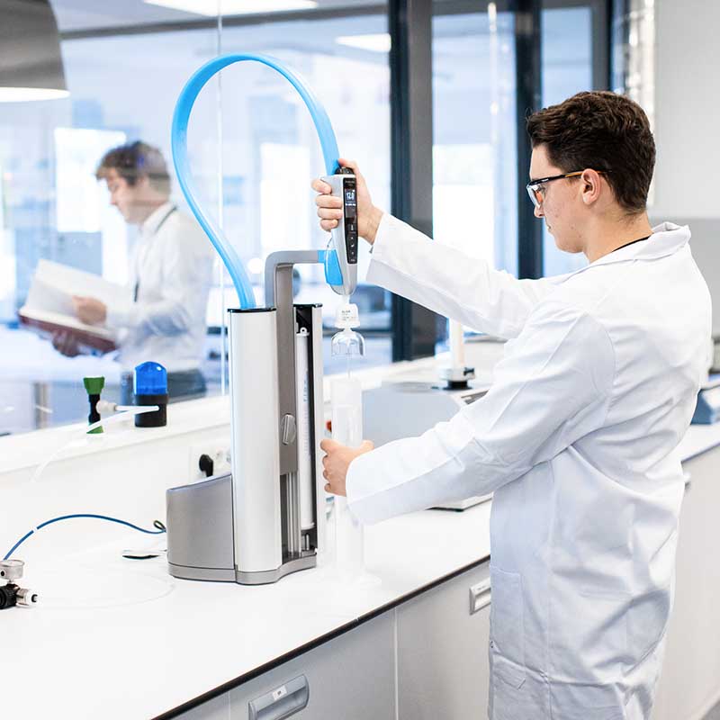 Photo santé Marseille : chercheur en blouse blanche manipulant un automate de précision dans un laboratoire médical de Paca.