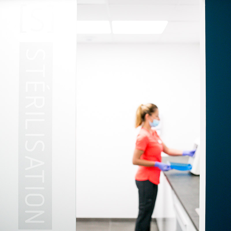 Photo santé Marseille : assistante médicale en tenue rose préparant la stérilisation du matériel dans une clinique Paca.