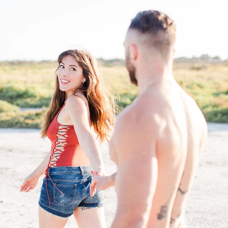 Photographe couple Marseille : amoureux marchant main dans la main sur une plage de la Méditerranée.